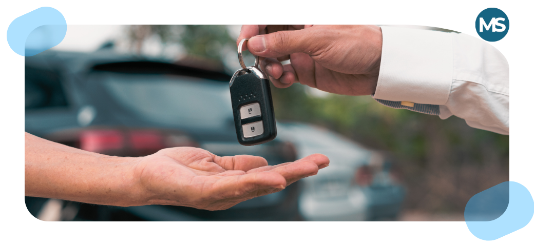Entrega de llaves de un coche entre dos personas, simbolizando la transferencia de un vehículo.