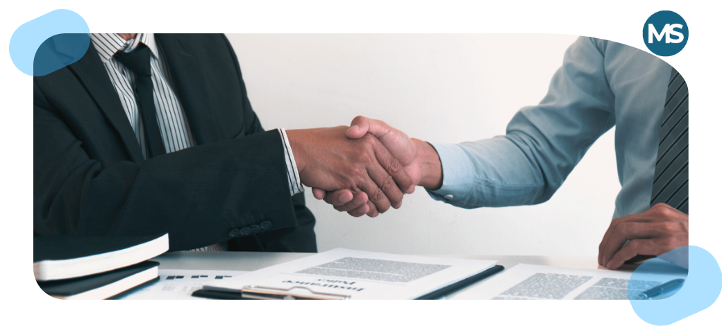 Dos personas estrechando la mano tras firmar un acuerdo de herencia