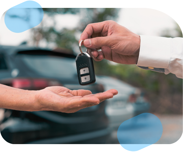 Entrega de llaves de un coche entre dos personas, simbolizando la transferencia de un vehículo.